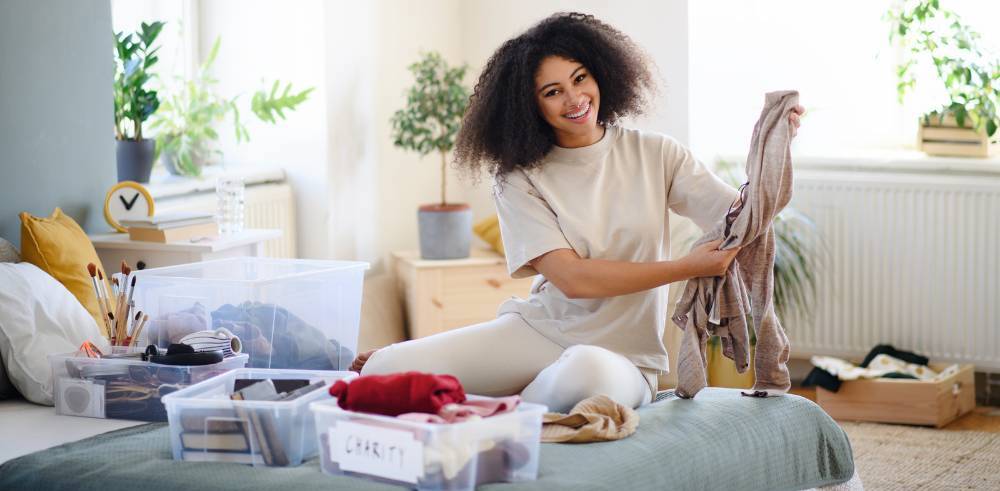 A woman organising folded clothes at home